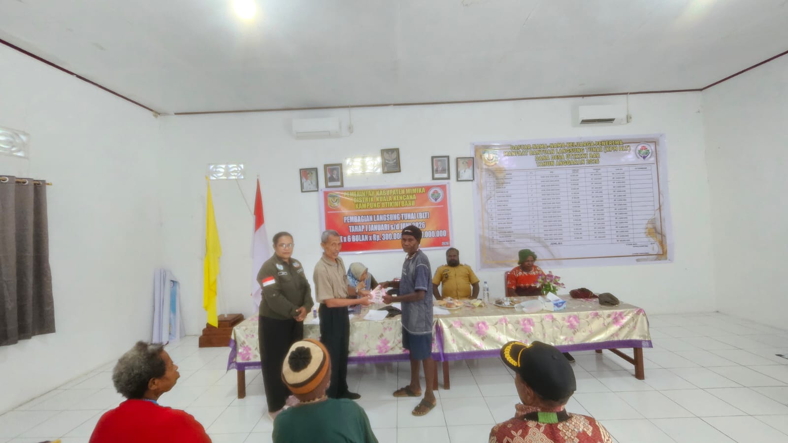 Sekertaris Kampung Utikini Satu, Arif Karsito saat menyerahkan BLT kepada salah seorang warga KPM disaksikan pendamping desa dan aparatur kampung 