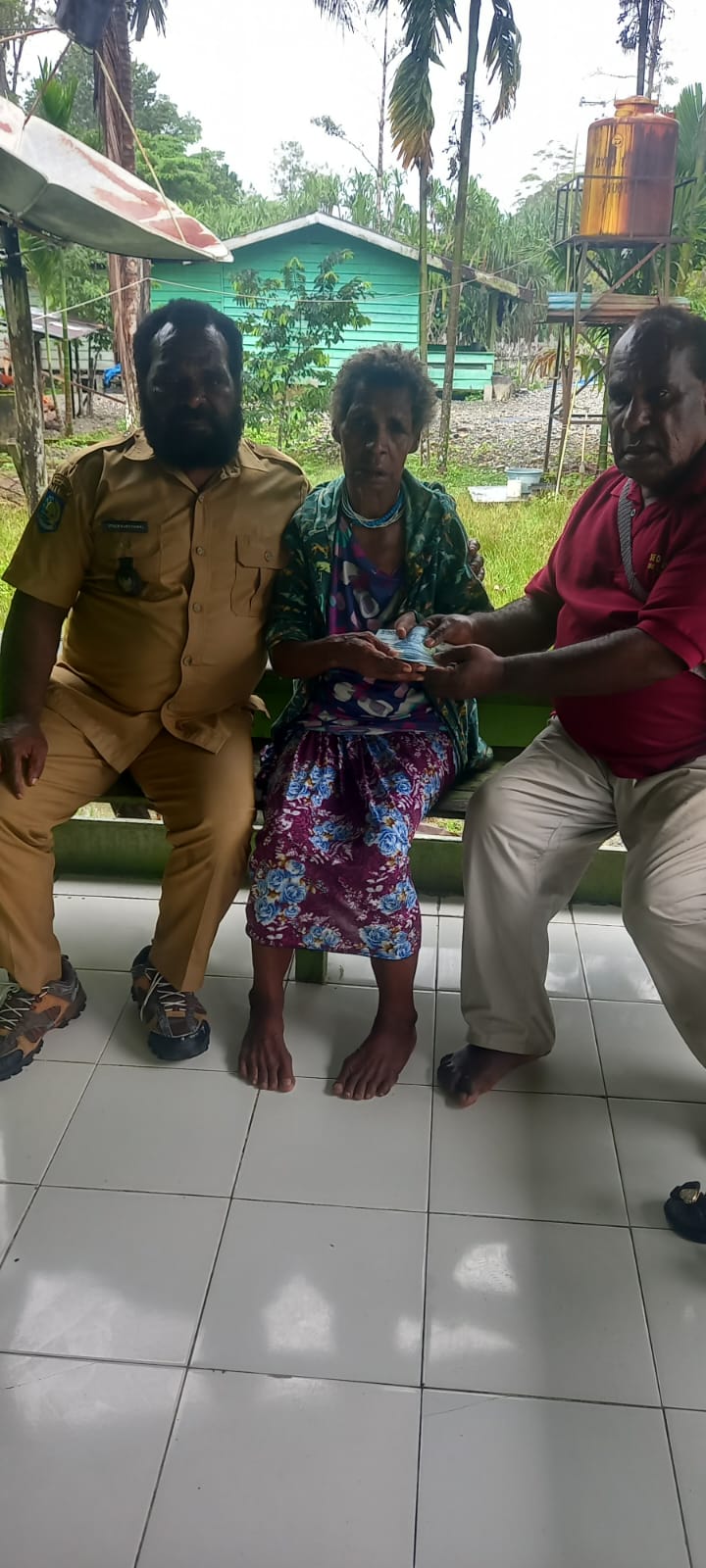 Kepala Kampung Utikini Satu saat menyerahkan Bantuan Langsung Tunai kepada warga
