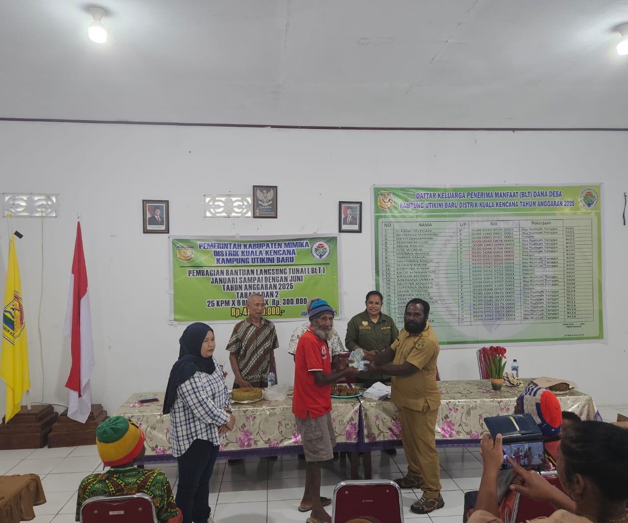 Kepala Kampung Utikini Satu saat menyerahkan Bantuan Langsung Tunai kepada warga
