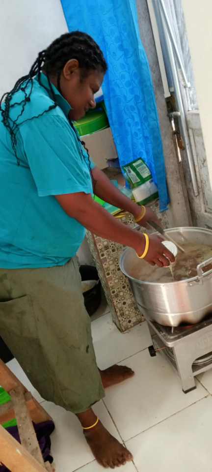 Seorang ibu sedang memasak bubur kacang hijau yang nantinya akan dibagikan kepada para balita