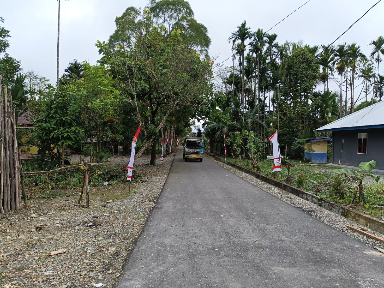 Jalan masuk menuju Kampung Karya Kencana yang telah  bersih dan dipasang umbul-umbul 