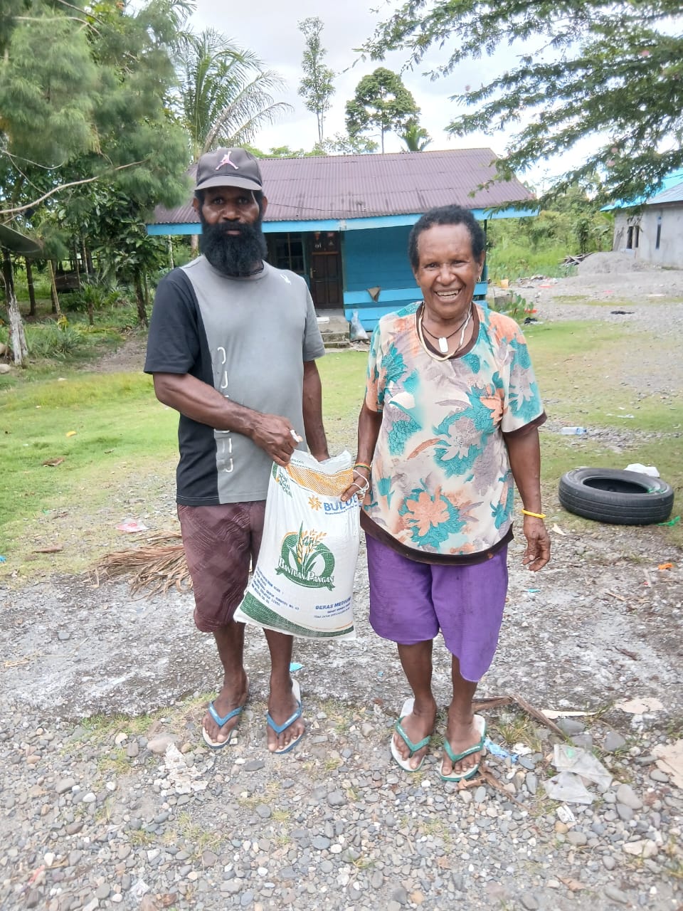 Aparatur Kampung Utikini I saat menyerahkan bantuan beras kepada warga