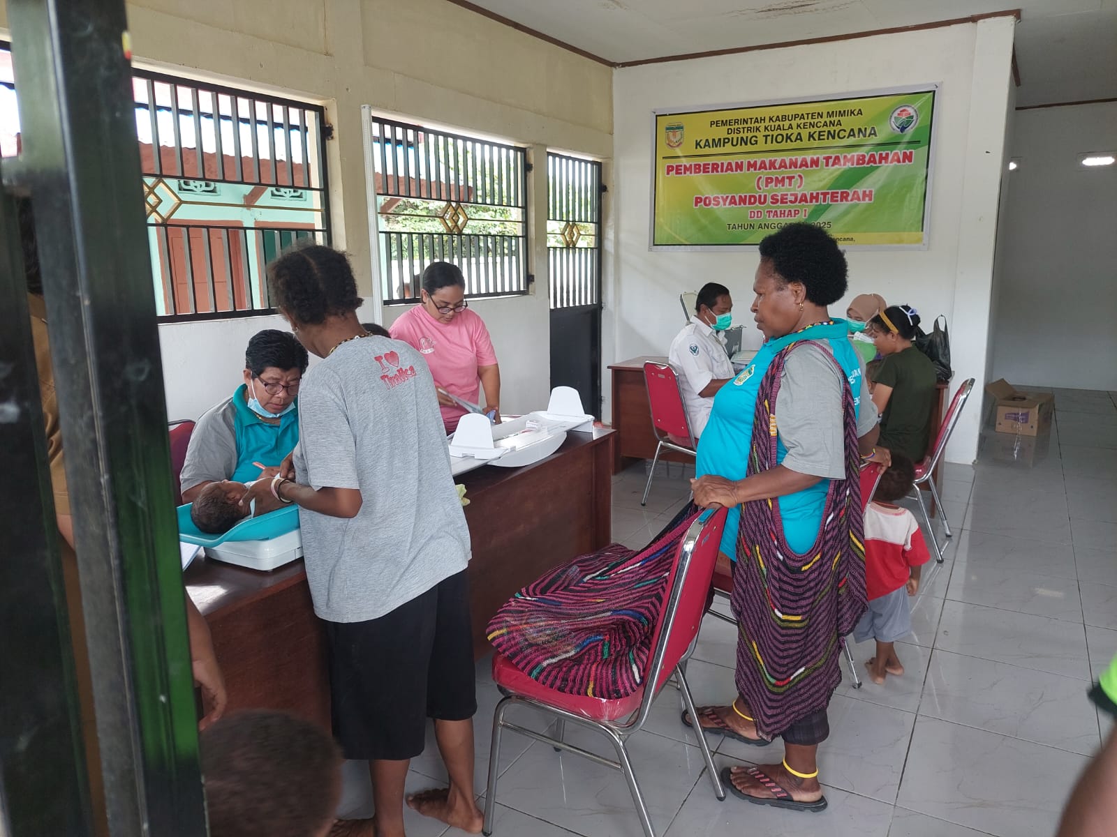 Kader Posyandu Kampung Tioka Kencana saat menimbang berat dan mengukur tinggi badan bayi