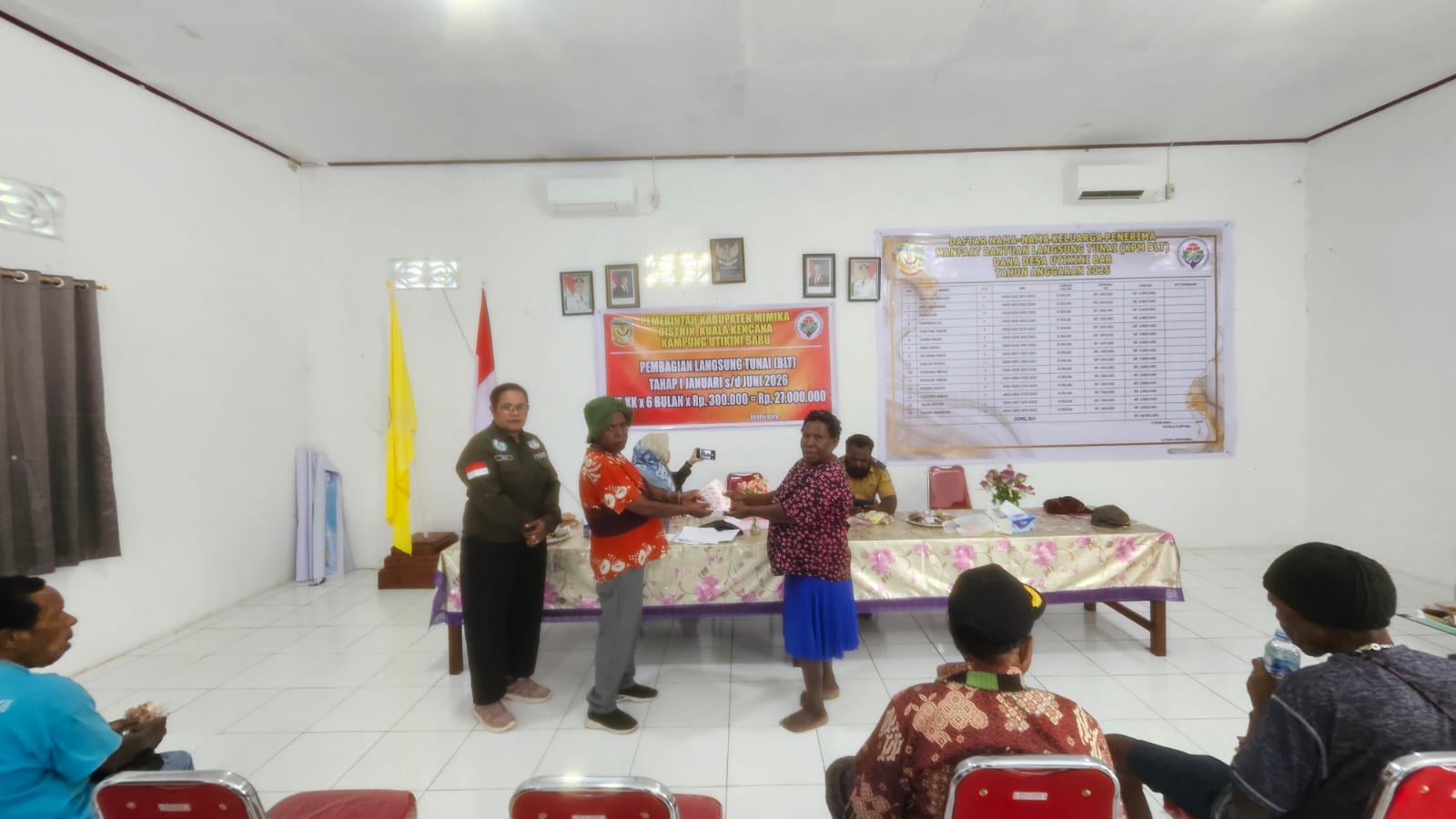 Salah satu aparatur Kampung Utikini Satu saat menyerahkan BLT kepada salah seorang warga KPM disaksikan pendamping desa dan aparatur kampung 