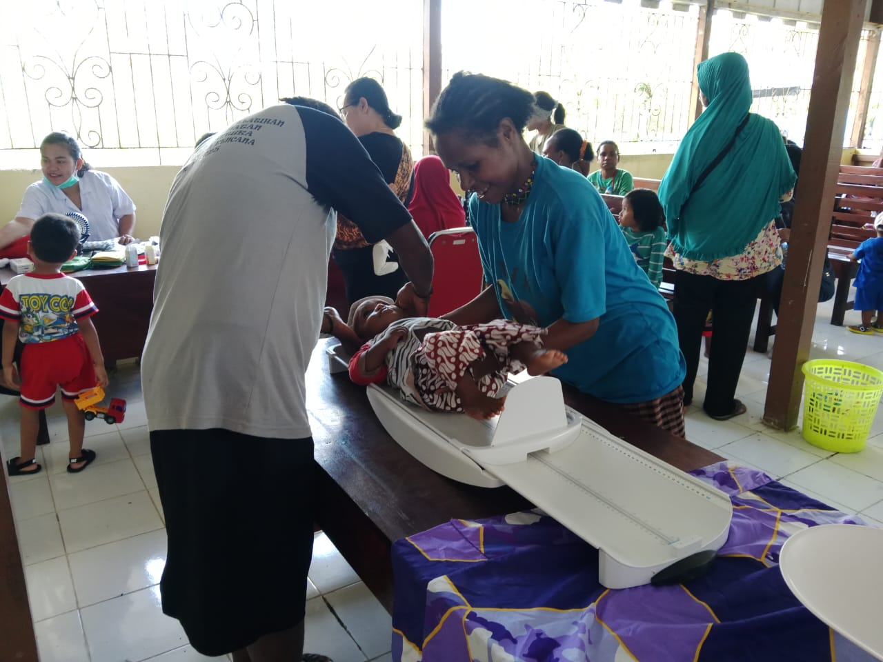 Seorang ibu saat membawa balitanya dan ditimbang oleh petugas kesehatan