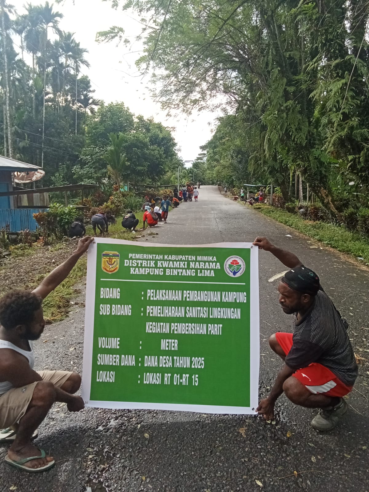 Warga memegang spanduk setelah selesai membersihkan Parit