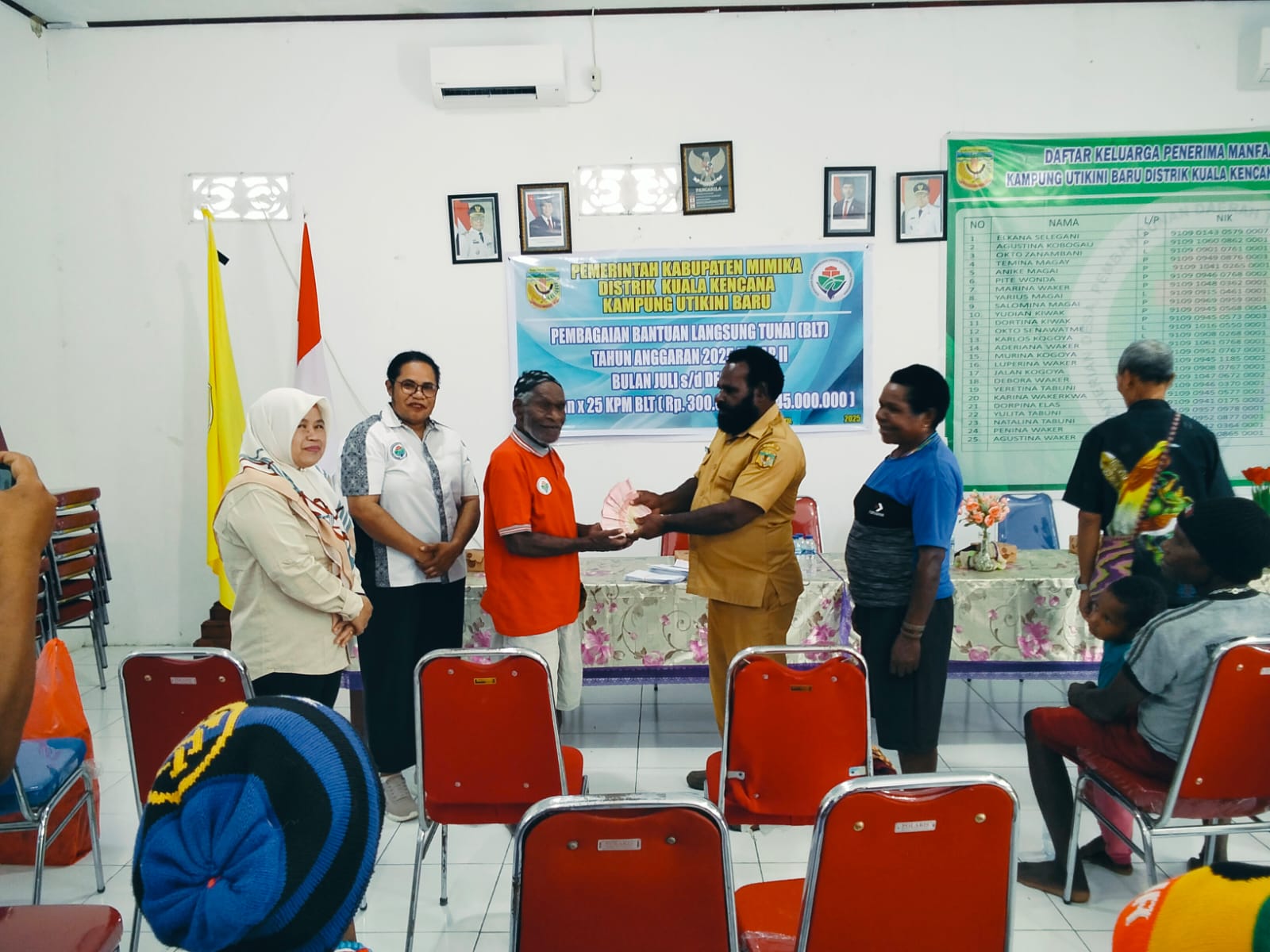 Kepala Kampung Utikini I, Luther Karagainal didampingi pendamping desa saat menyerahkan BLT kepada KPM