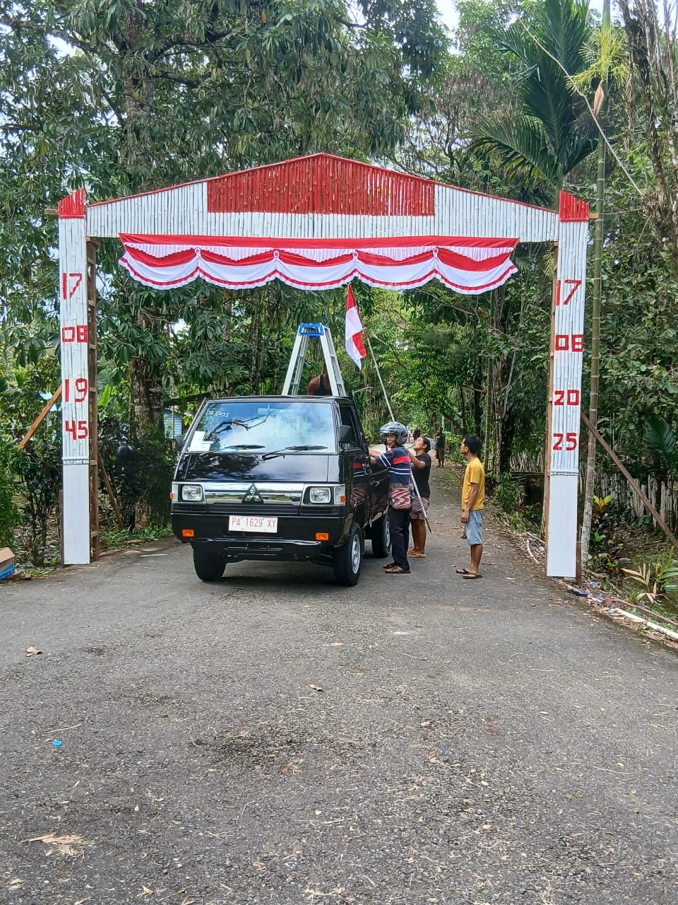 Kepala Kampung Utikini I bersama warga membuat gapura
