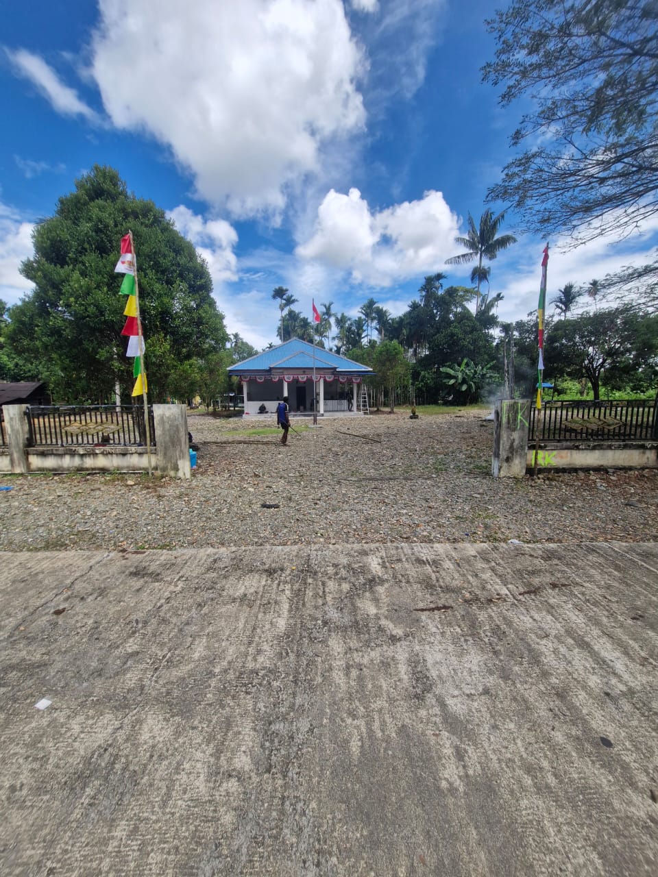 Suasana jalan masuk ke Kantor Kampung Jimbi yang sudah terpasang umbul-umbul dan bendera