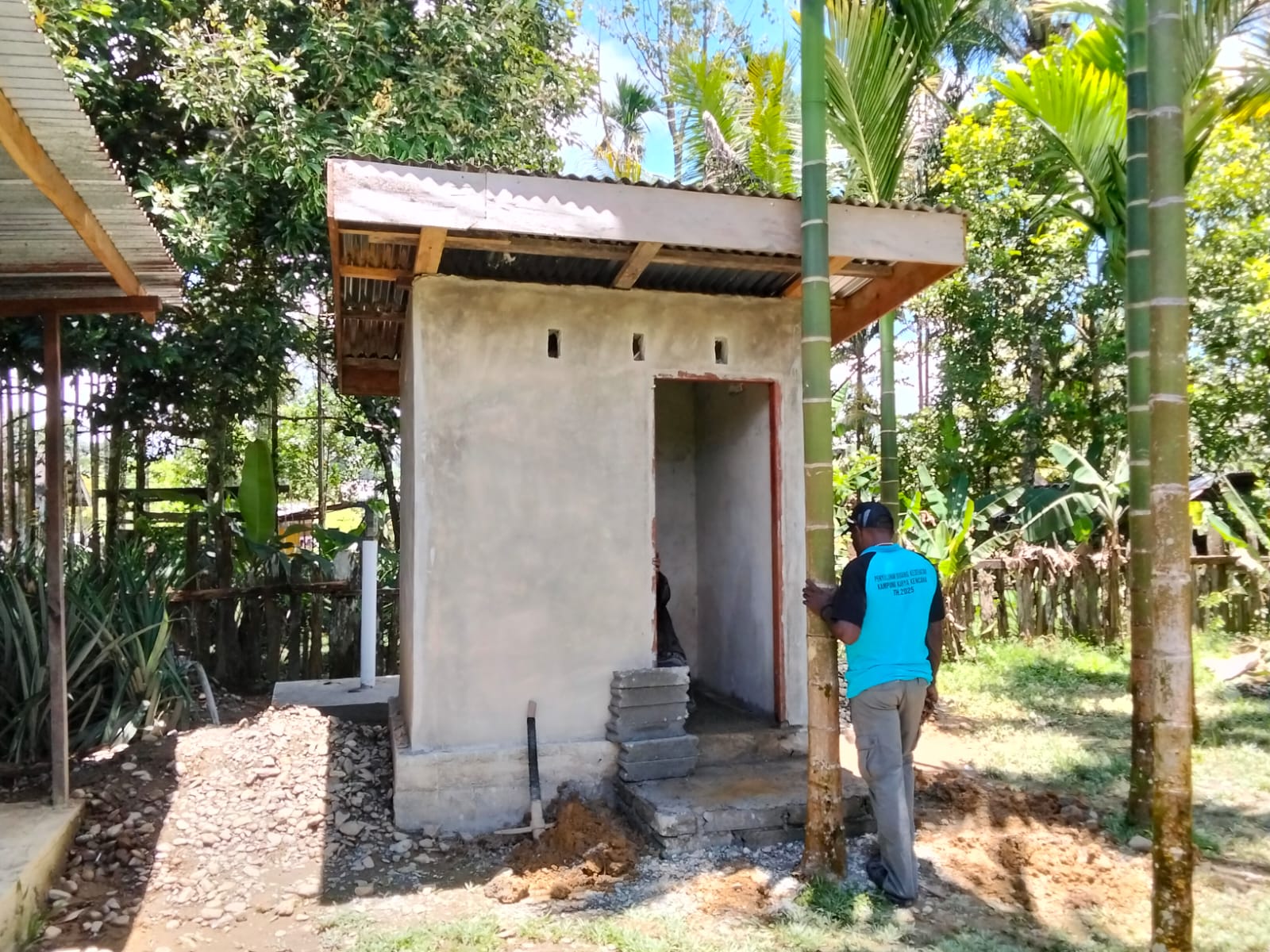 Kepala Kampung Karya Kencana, Rakam Suntoro saat meninjau pembangunan MCK