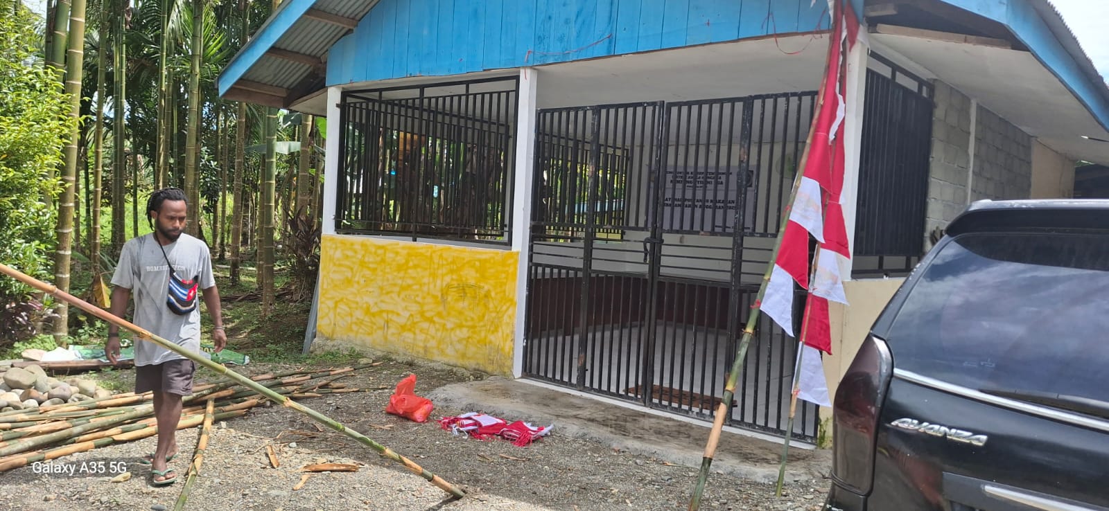 Proses pemasangan umbul-umbul di Kantor Kampung Utikini II