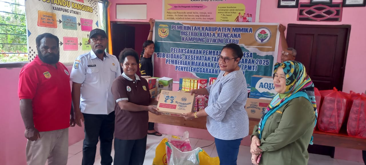 Pendamping desa saat menyerahkan makanan tambahan kepada warga