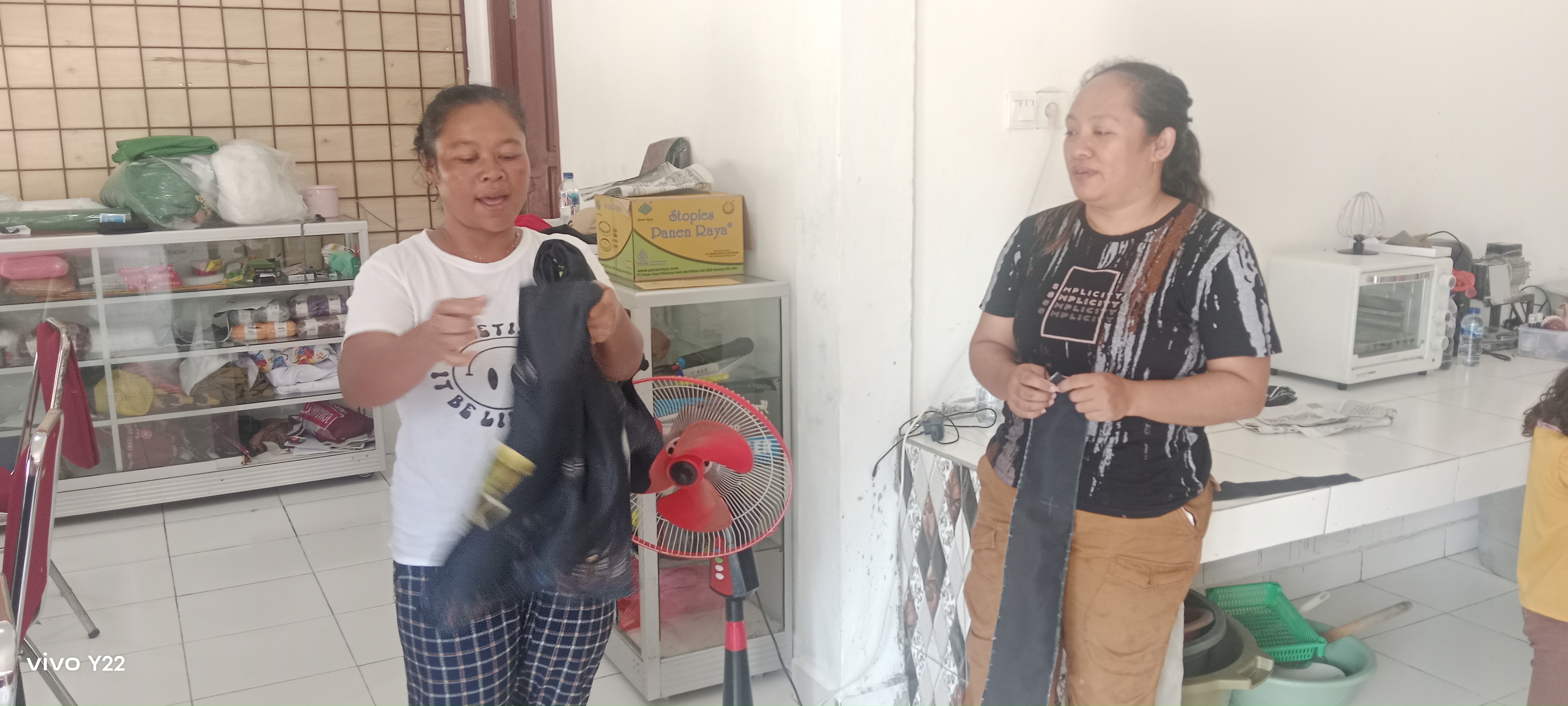 Kedua ibu-ibu PKK Kampung Utikini Satu saat menunjukkan kain yang akan mereka jahit