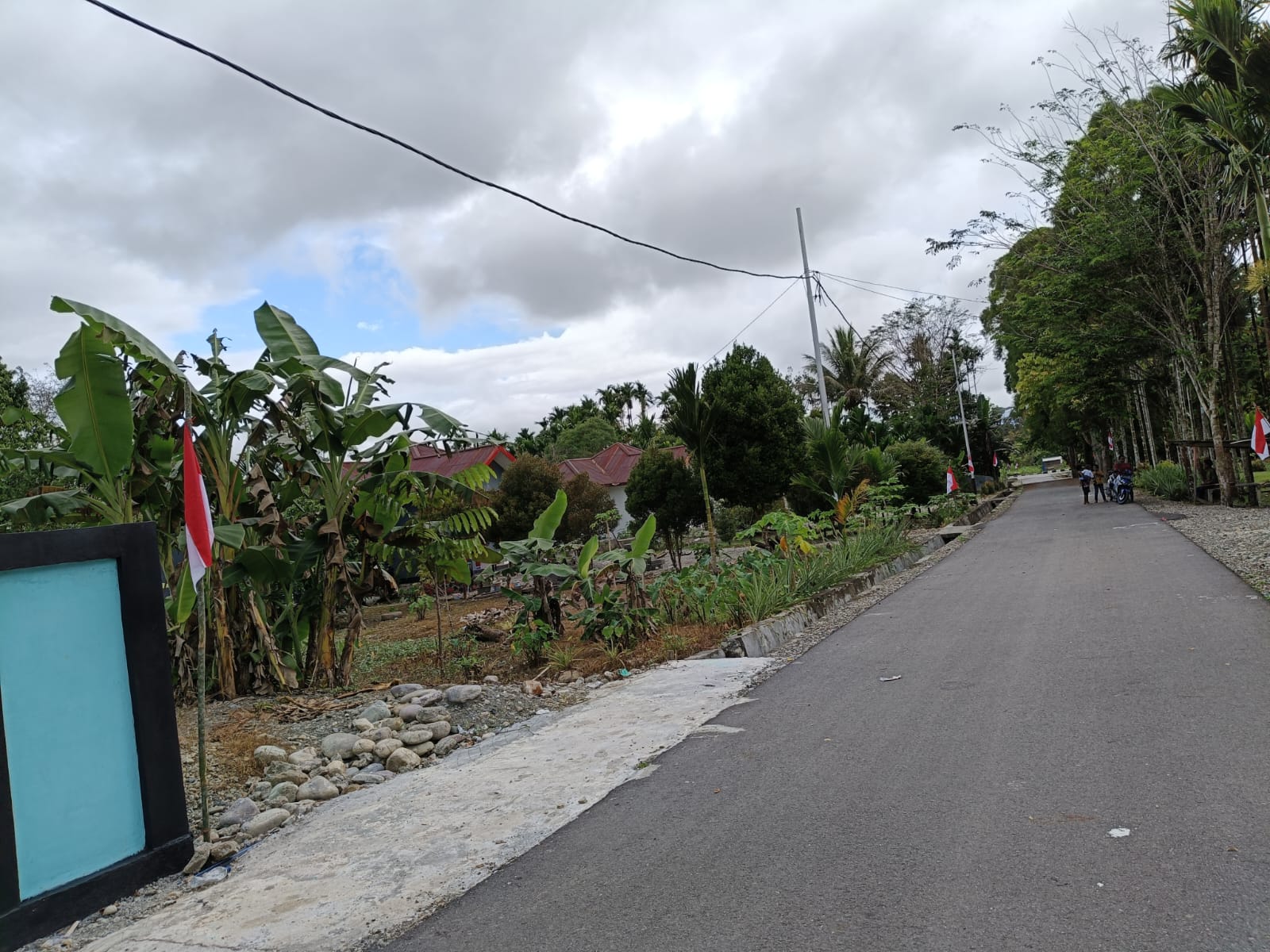 Warga saat menancapkan tiang bendera merah putih didepan rumah warga