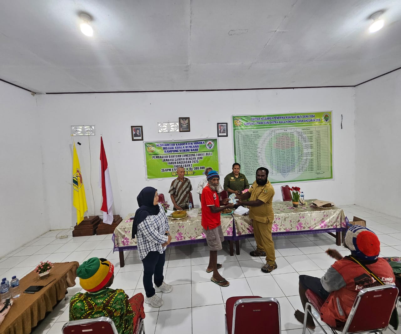 Kepala Kampung Utikini Satu, Luther Karagainal saat menyerahkan Bantuan Langsung Tunai kepada warga