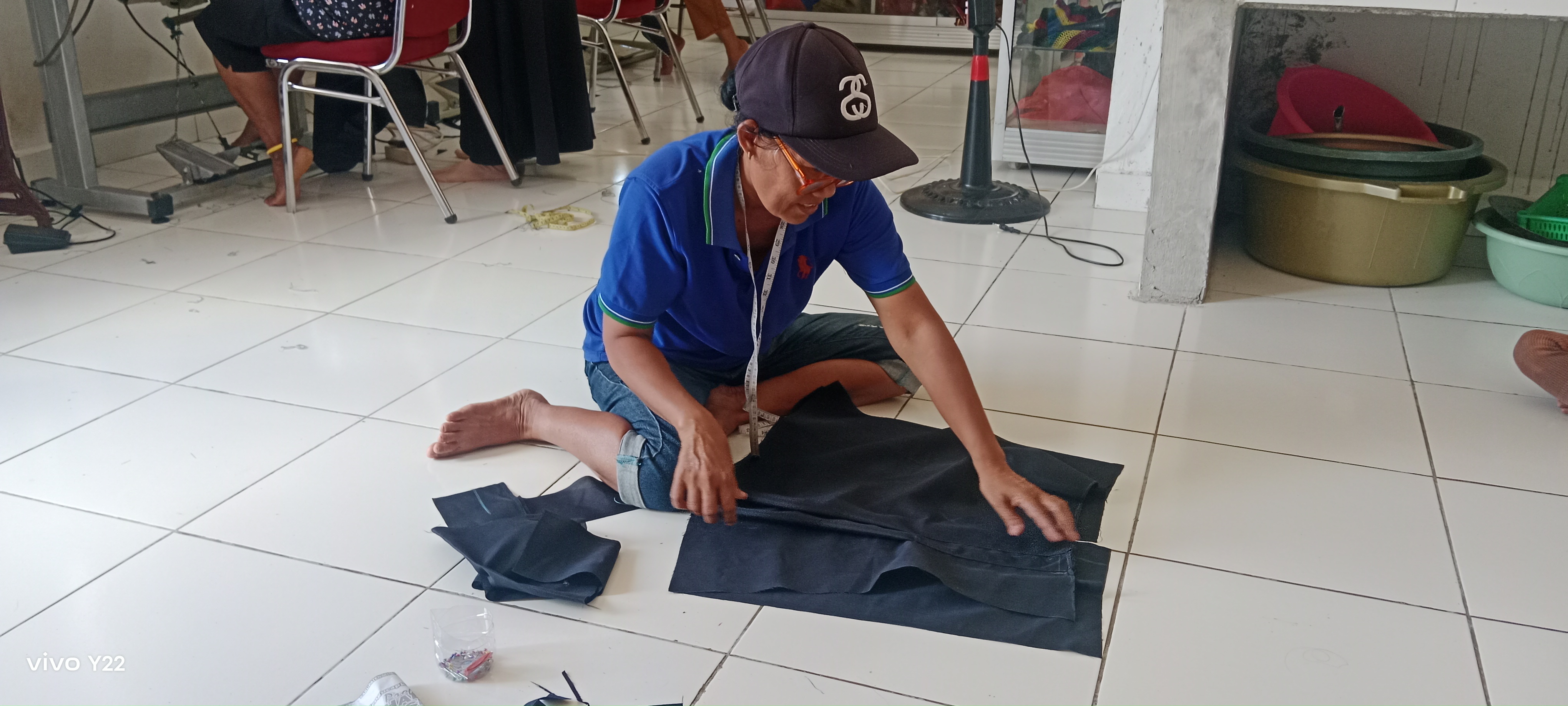 Seorang ibu-ibu PKK Kampung Utikini Satu saat mengukur kain untuk kemudian dipotong dan dijahit